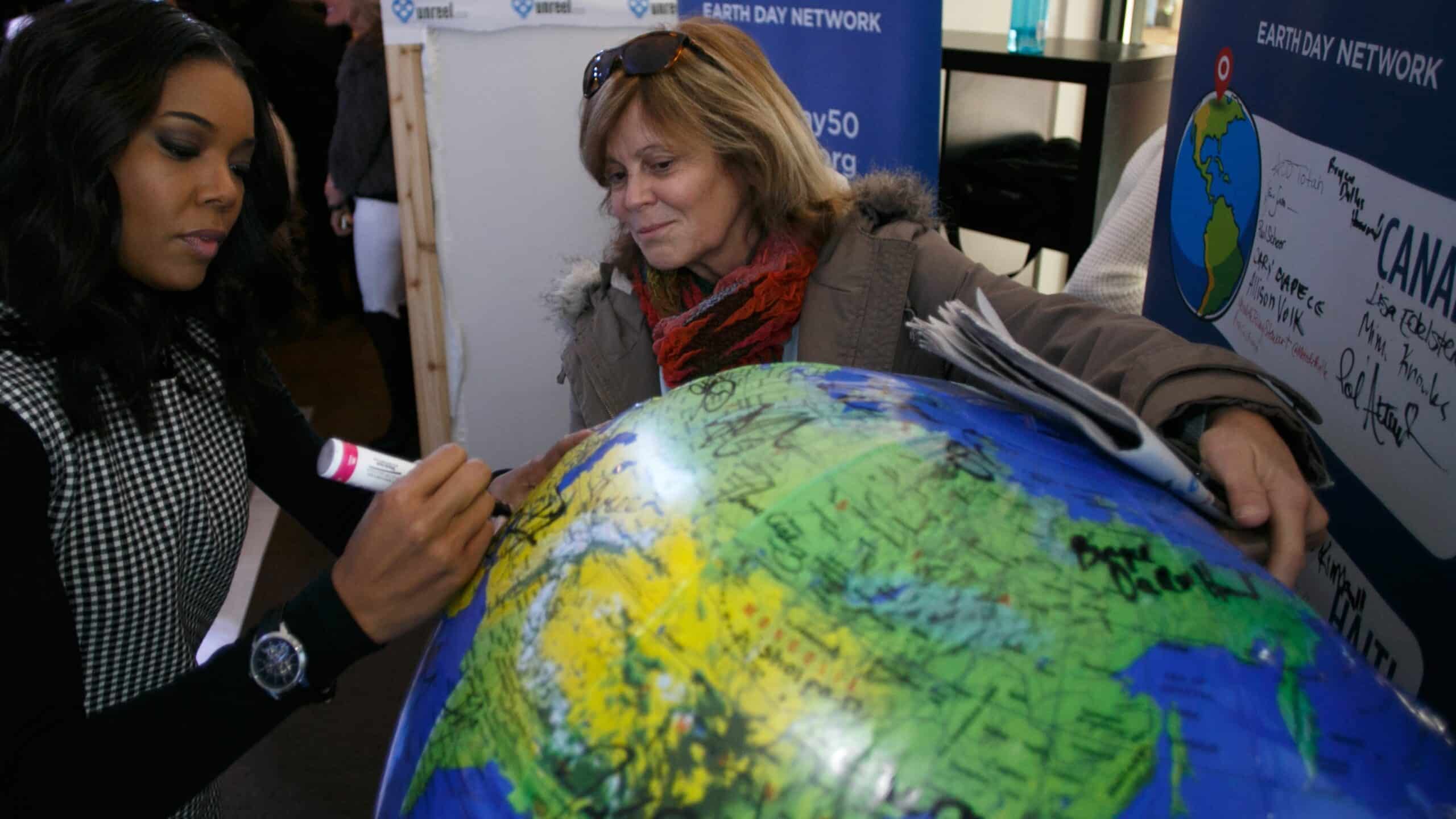 <br />
Earth Day Network President Kathleen Rogers, right, looks on at the Toyota Mirai Music Lodge as Gabrielle Union, left, signs her name on an inflatable globe to express her support for the Earth Day Network's effort to plant 7.8 billion trees while Earth Day Network president  as part of the Sundance Film Festival on Monday, Jan. 25, 2016, in Park City, Utah. 