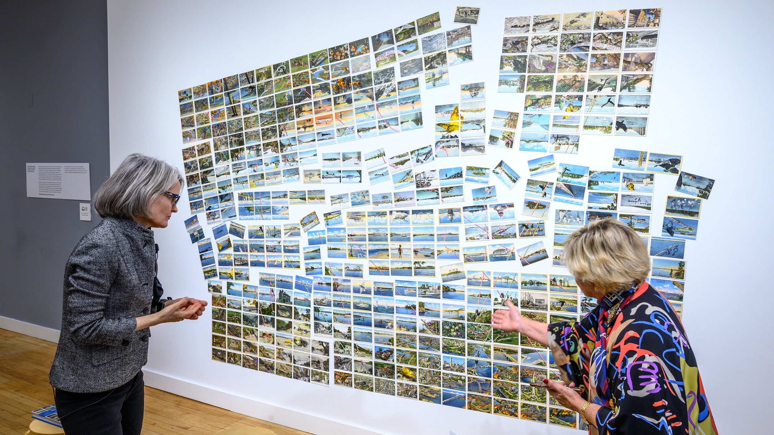 Climate Museum director Miranda Massie (L) answers questions about the mural called “Someday, all this” by artist David Opdyke in their pop-up site in Soho, New York city.<br />
