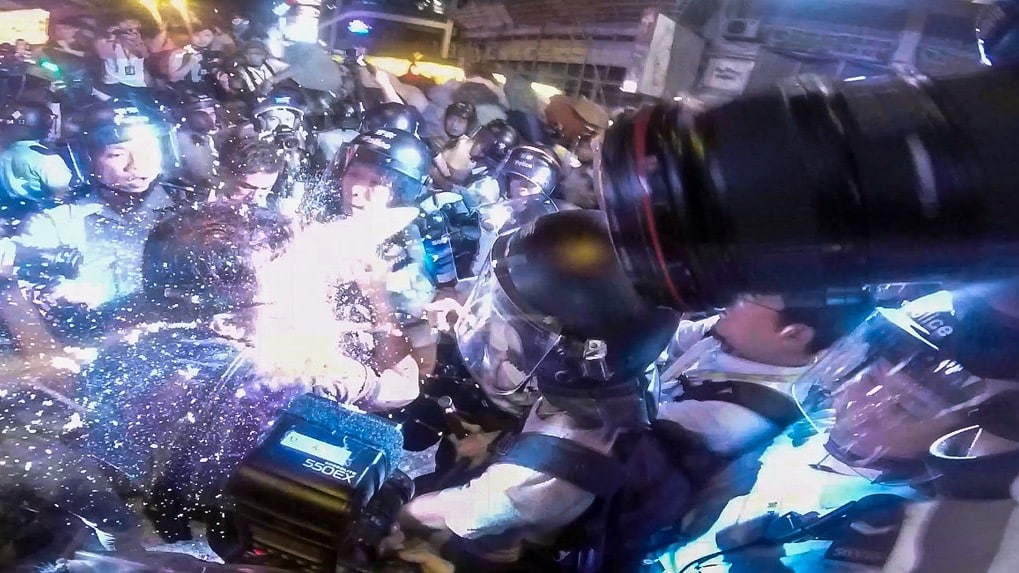 A camera catches the pepper spraying by police of a journalist covering protests in Hong Kong in 2014.