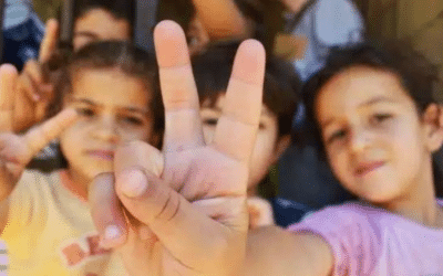 Syrian refugee children in Lebanon make the peace sign.